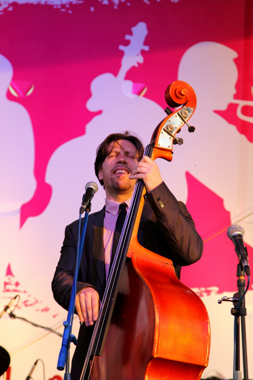 man playing cello in front of microphone