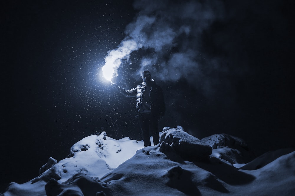 standing man holding light during nighttime