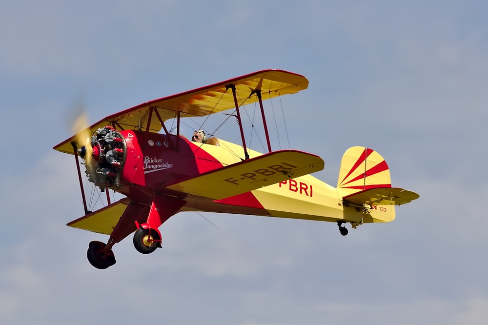 low angle photo of yellow and red biplane