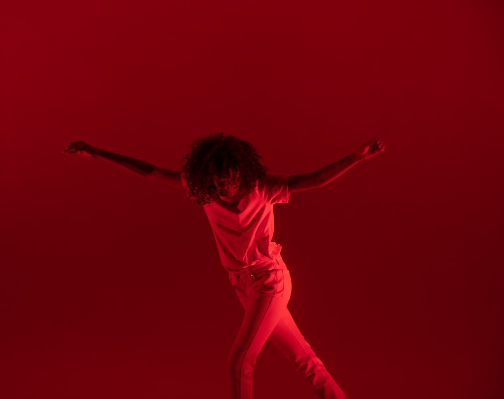 fotografia di donna che balla vicino a sfondo rosso