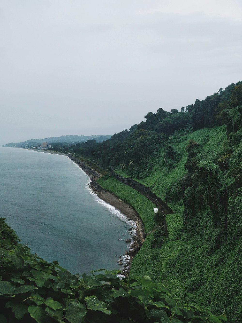 body of water beside mountain at daytime