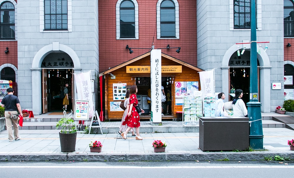 a woman in a red dress is walking down the street