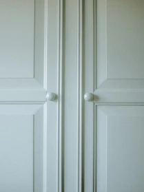 A stylish kitchen cabinet featuring elegant knobs and smooth hinges under warm lighting.