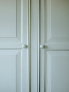 A detailed close-up of bespoke wood cabinetry showcasing smooth finishes and precise joinery in a bright, airy kitchen.