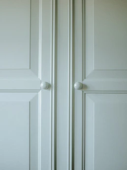 Close-up of a sleek, modern cabinet corner showcasing smooth white pearl melamine with precise edging.