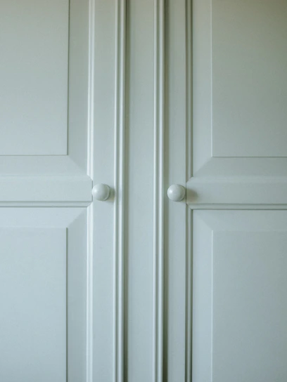 A detailed close-up of bespoke wood cabinetry showcasing smooth finishes and precise joinery in a bright, airy kitchen.