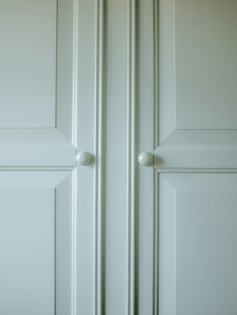 a close up of a white door with two knobs