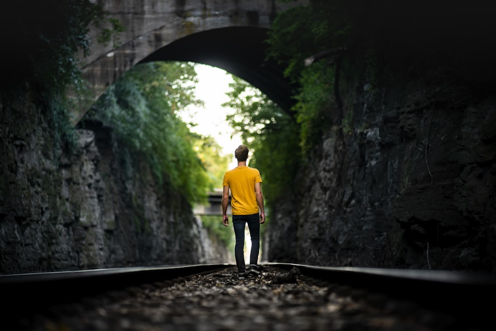 hombre que camina en la vía del tren durante el día