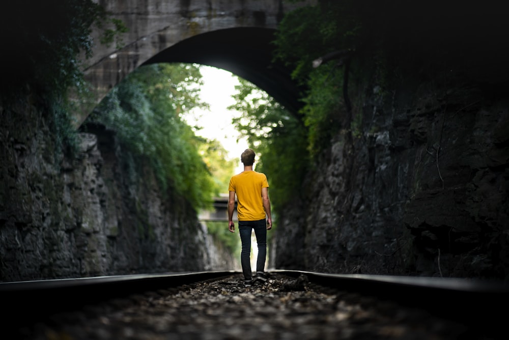 man walking on train track during day
