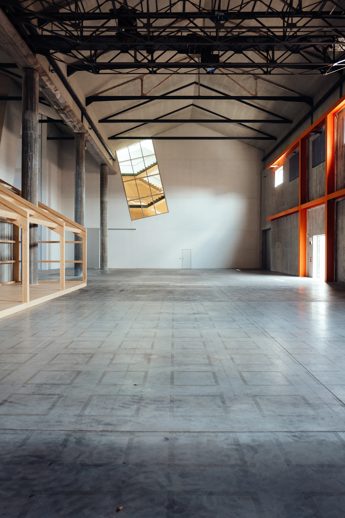 Unfinished commercial interior with exposed concrete floor and bare walls, an example of essential-tier commercial finishes