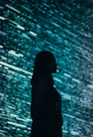 a woman standing in front of a large screen