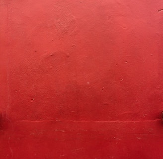 a red wall with a fire hydrant on it