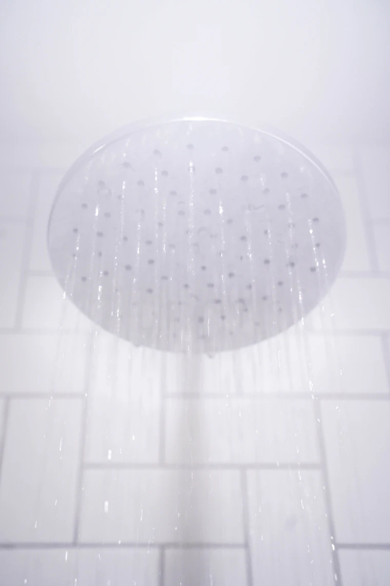 Water running from a shower head in a home with hard water