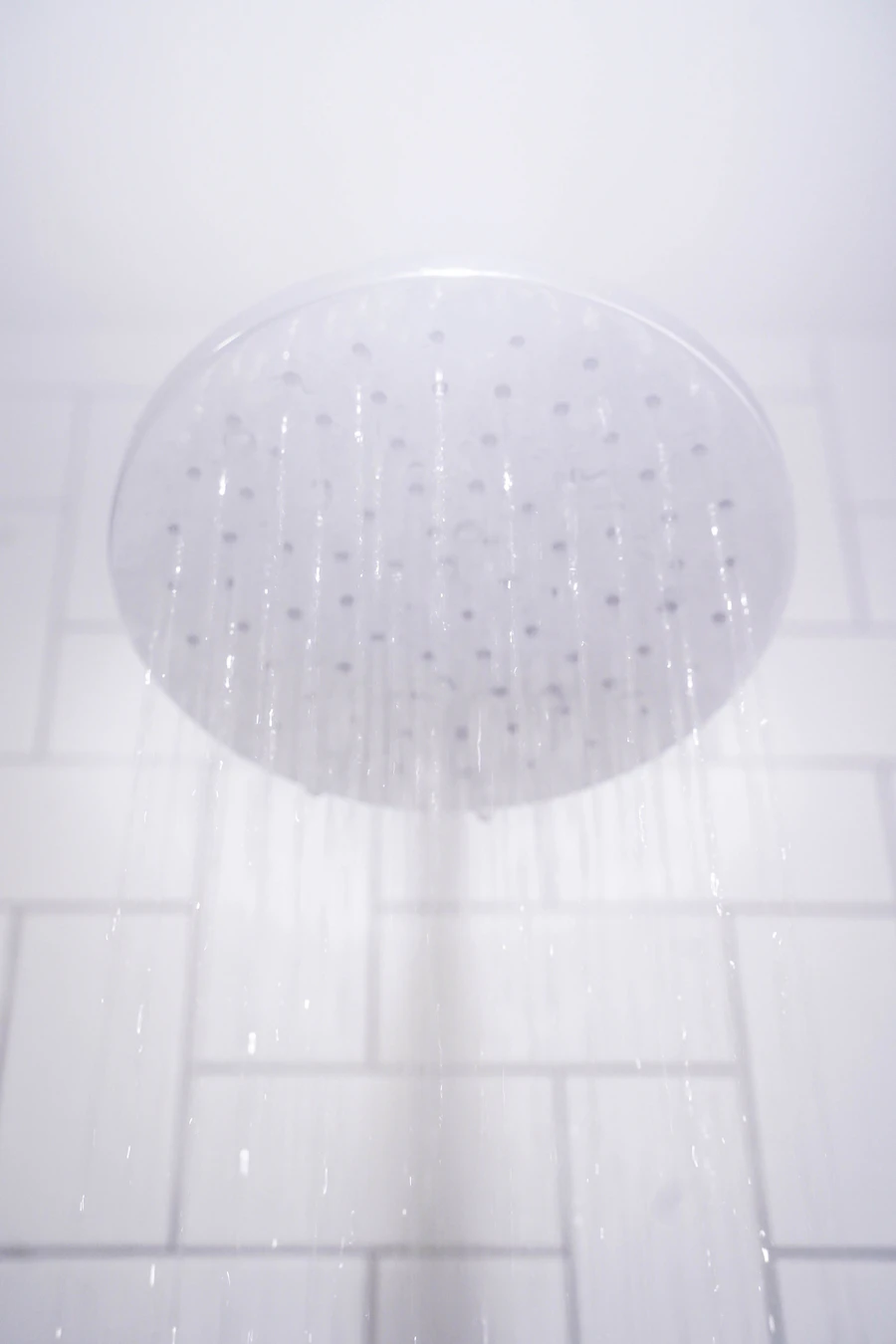 Shower head delivering water, representing instant hot water