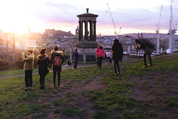 A group of professionals enjoying a sunset view on a corporate tour, with city skyline in the background.