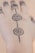 Intricate henna or mehndi design adorns the top of a hand, featuring floral patterns connected by a series of dots. The design extends over several fingers, with symmetrical details enhancing its aesthetic appeal.