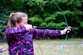 girl drawing composite bow before shooting