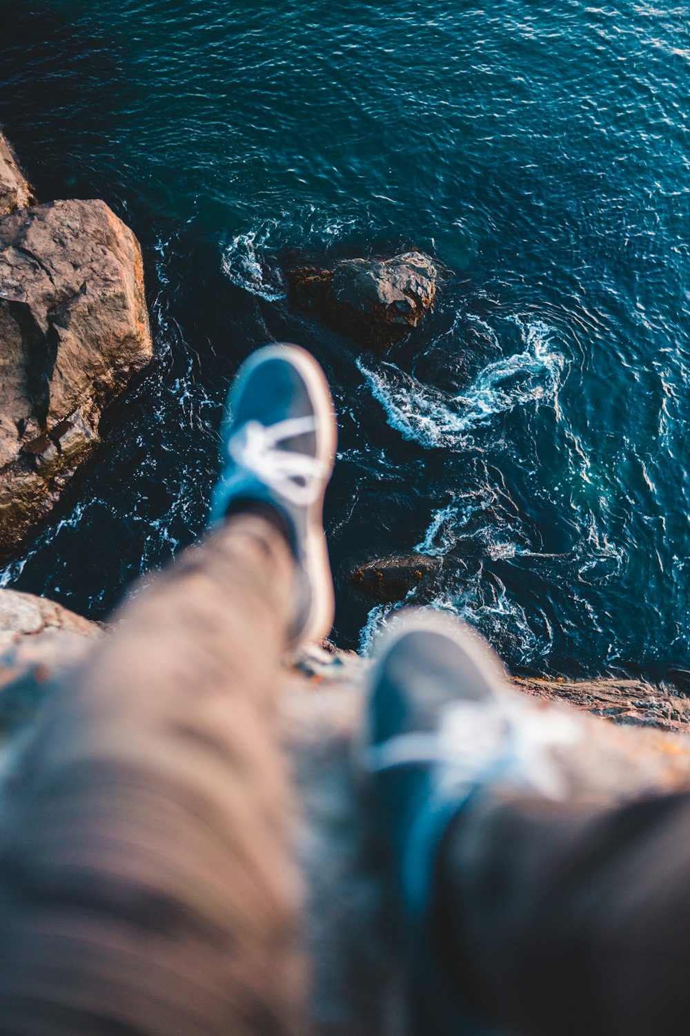 a person standing on a rocky shore next to a body of water