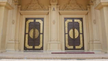 A grand entrance of a Bangalore villa showcasing classic luxury with gold-trimmed doors and refined landscaping.