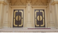 Close-up of a beautifully designed villa entrance showcasing intricate woodwork and gold accents.