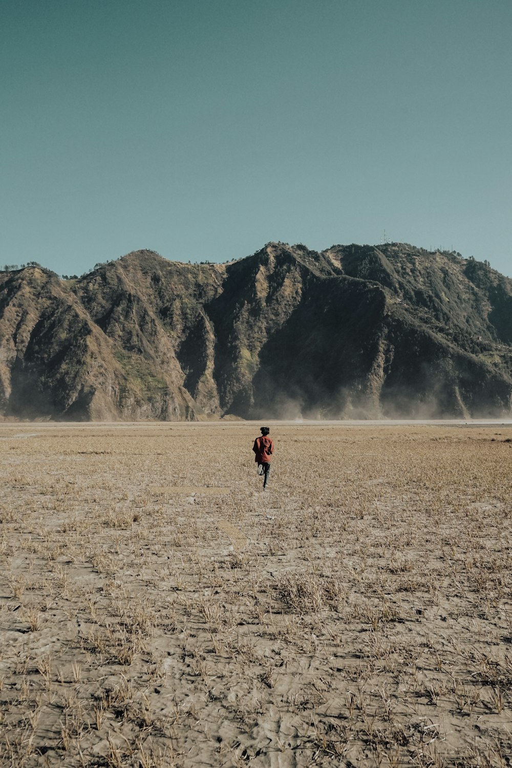 man running in the field near mountain