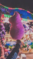 Close-up of fluffy pink and blue cotton candy spinning at a lively event.