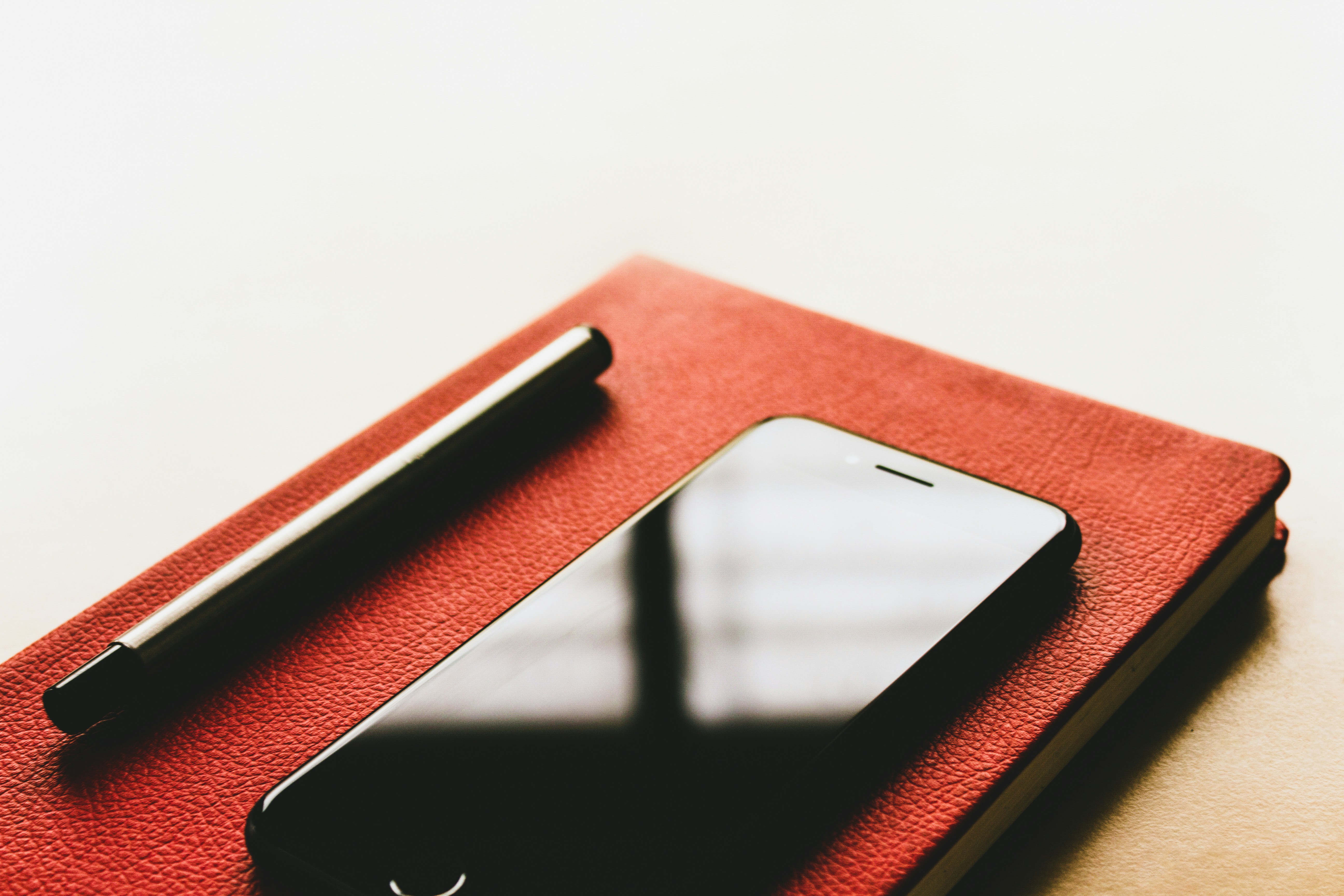 black iPhone on red book, 