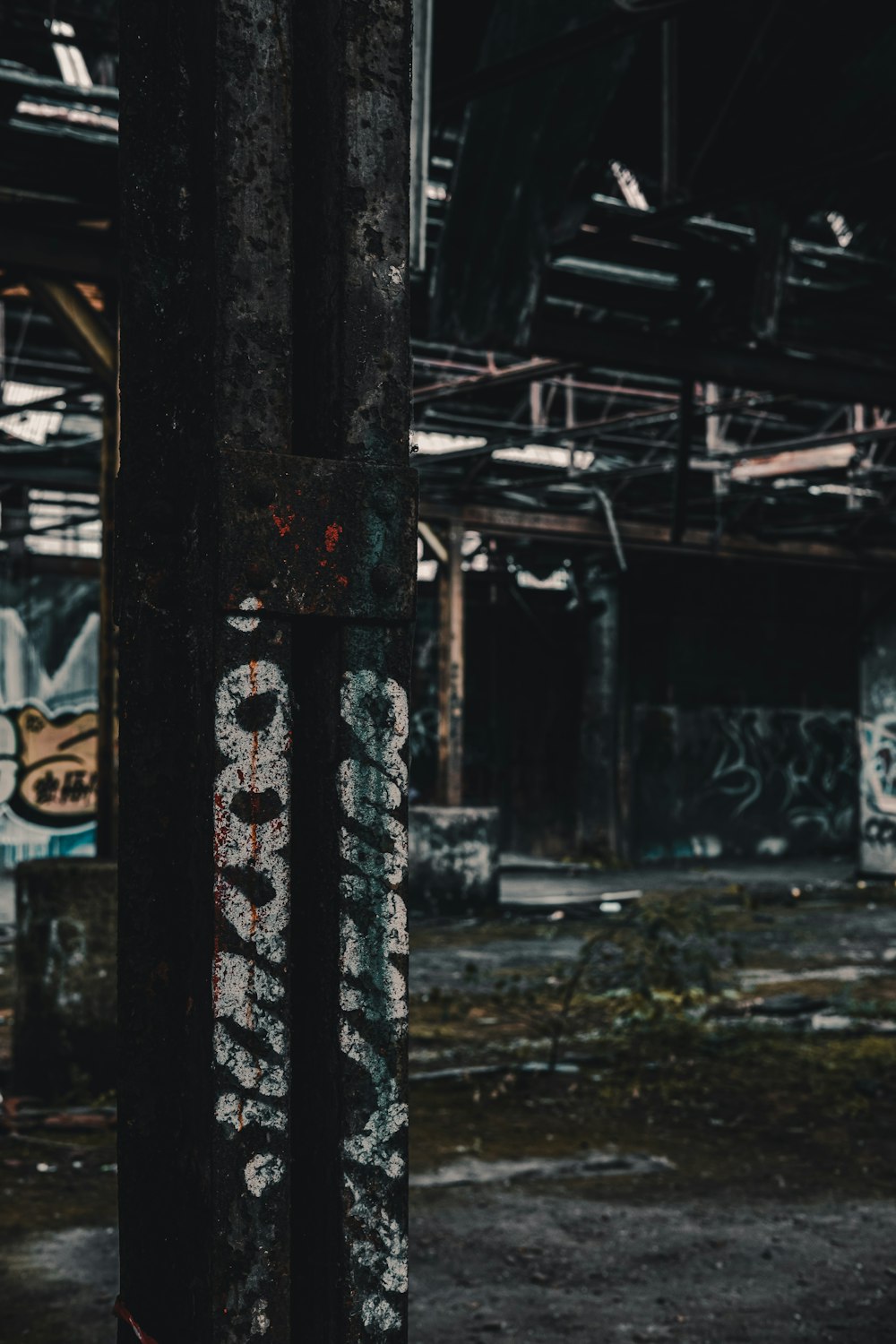 Schwarze Metallsäule mit weißem Grafitti