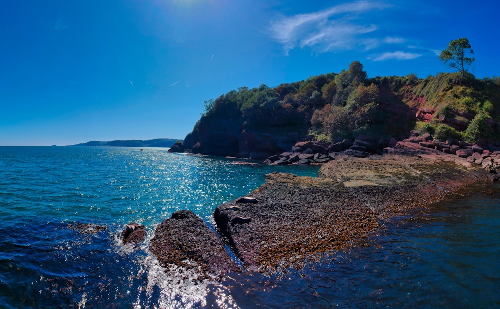 green mountain range beside seashore during daytime