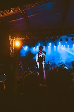 Aneeq Malik performing passionately on stage under vibrant lights.