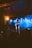 A captivated audience watching a magician perform on stage with dramatic lighting.