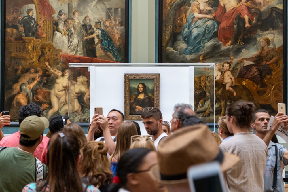pessoas reunidas perto da pintura de Monalisa