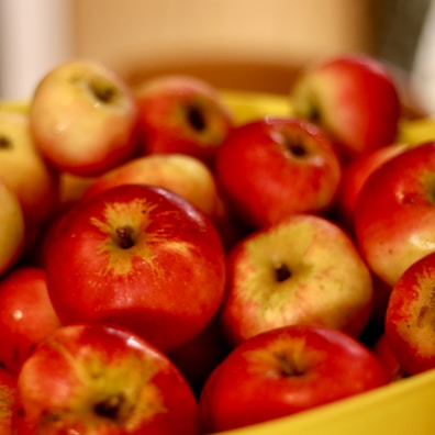 A close-up of shiny red apples stacked in a basket.