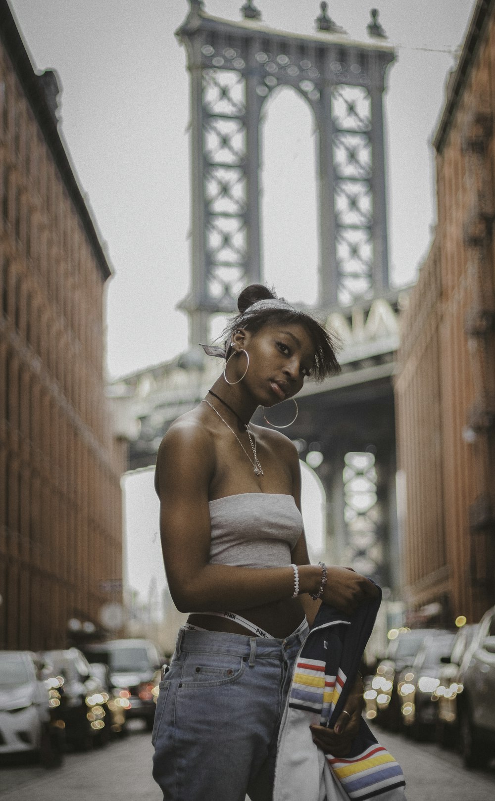 a woman standing on a street with a skateboard