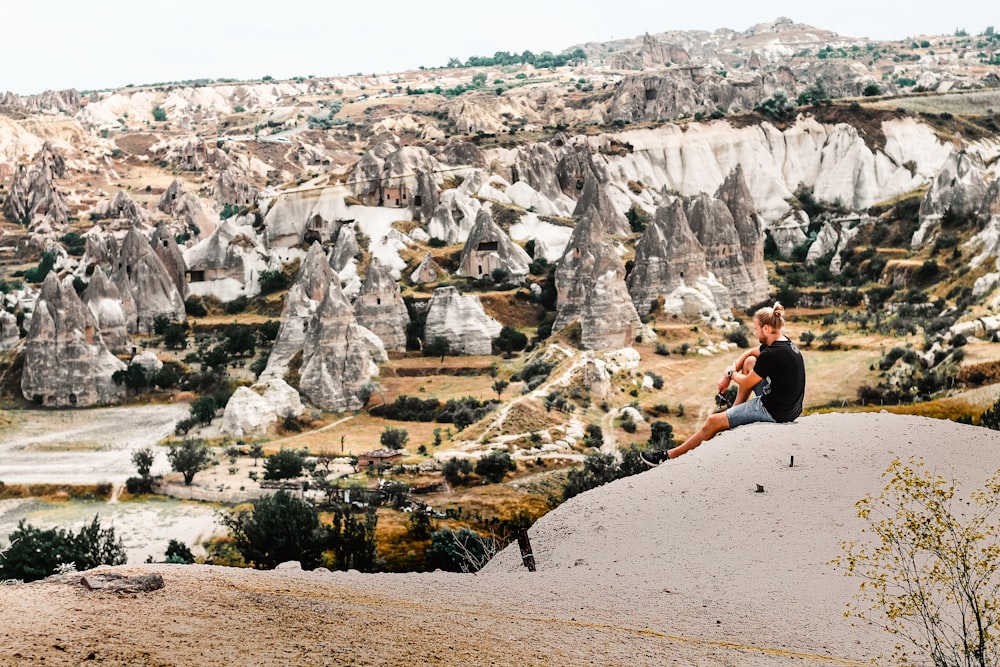 man sitting on rock formation