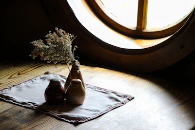 Sunlight streaming through a window onto a rustic table set with Clay Hearth stoneware.