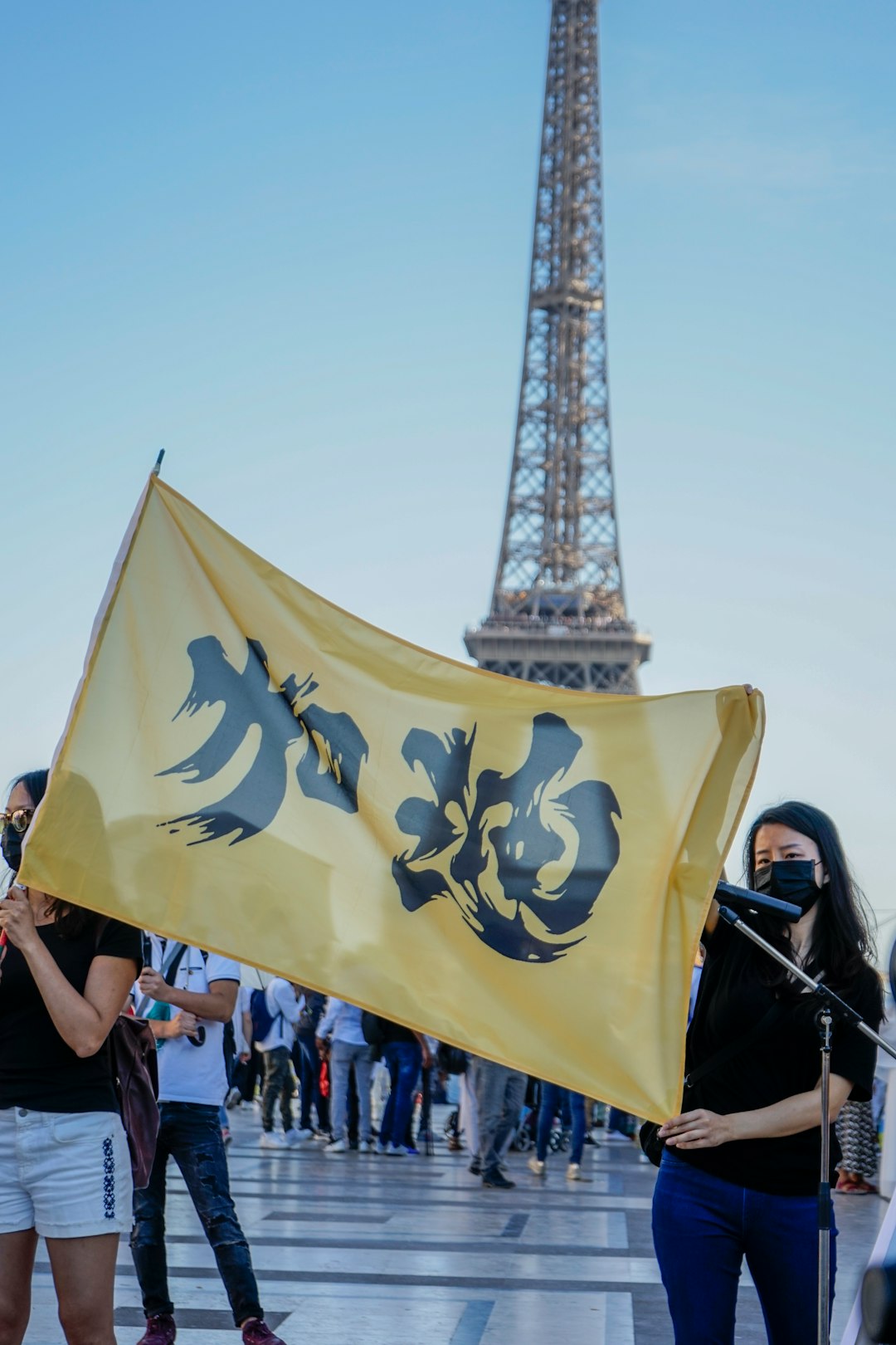 two women holding yellow flag with kanji script