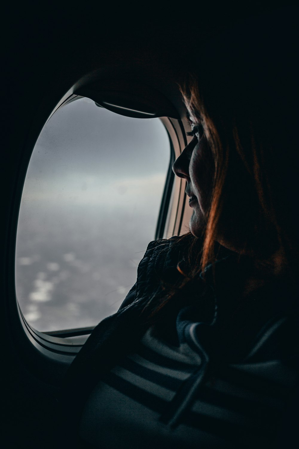 man sitting beside airplane clear glass window