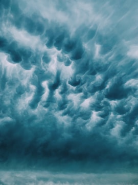 A swirling cosmic storm with faint, ghostly faces trapped within the dark clouds, symbolizing fear’s grip.