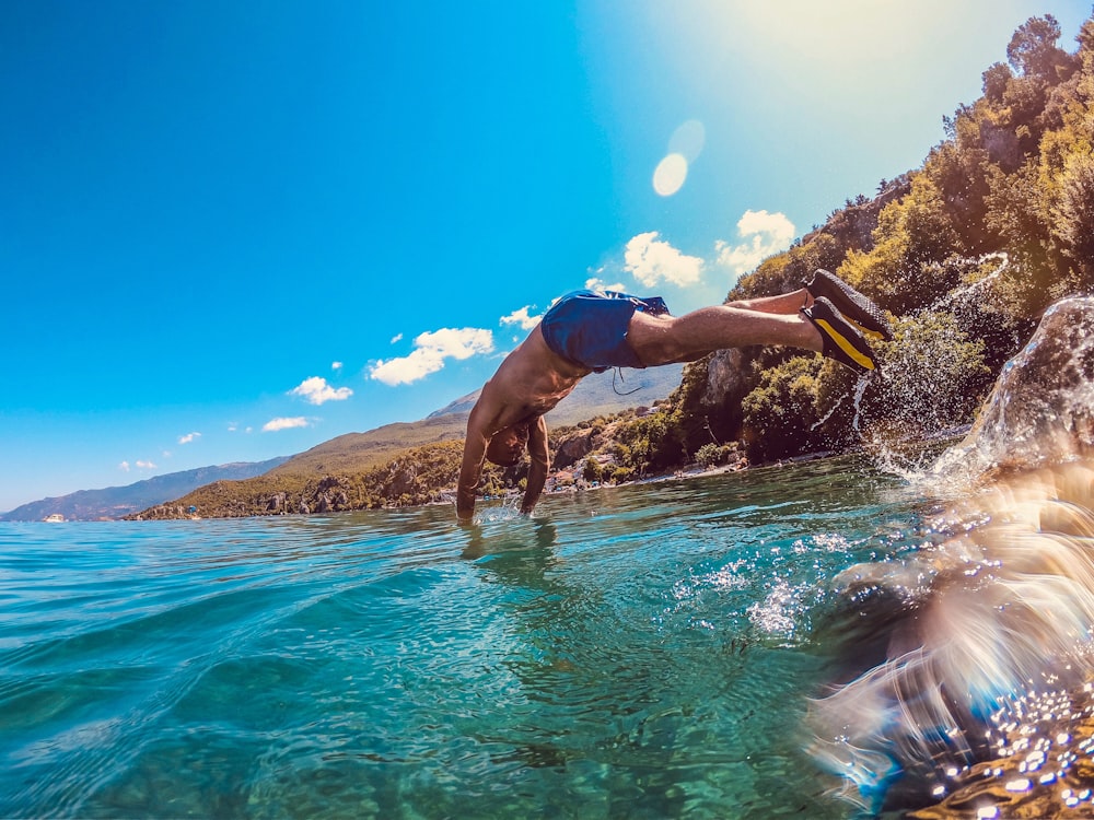 long-exposure photography man diving on body of water