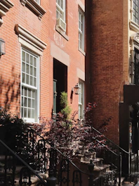 Renovated historic brick building with fresh paint and landscaping, blending old charm with new life.
