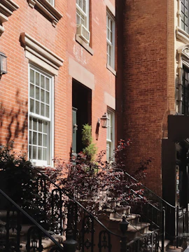 Renovated historic brick building with fresh paint and landscaping, blending old charm with new life.