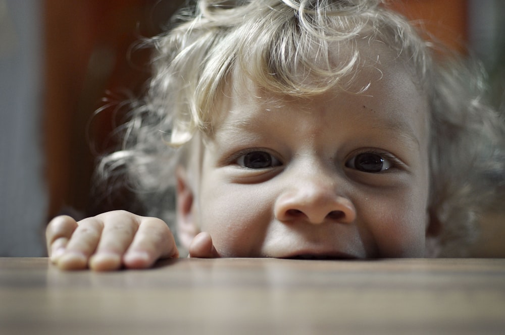 closeup photo of boy biting wood slab