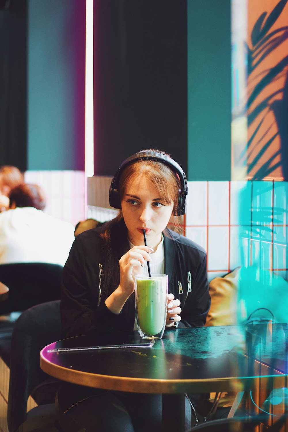 woman sitting and sipping beverage from straw