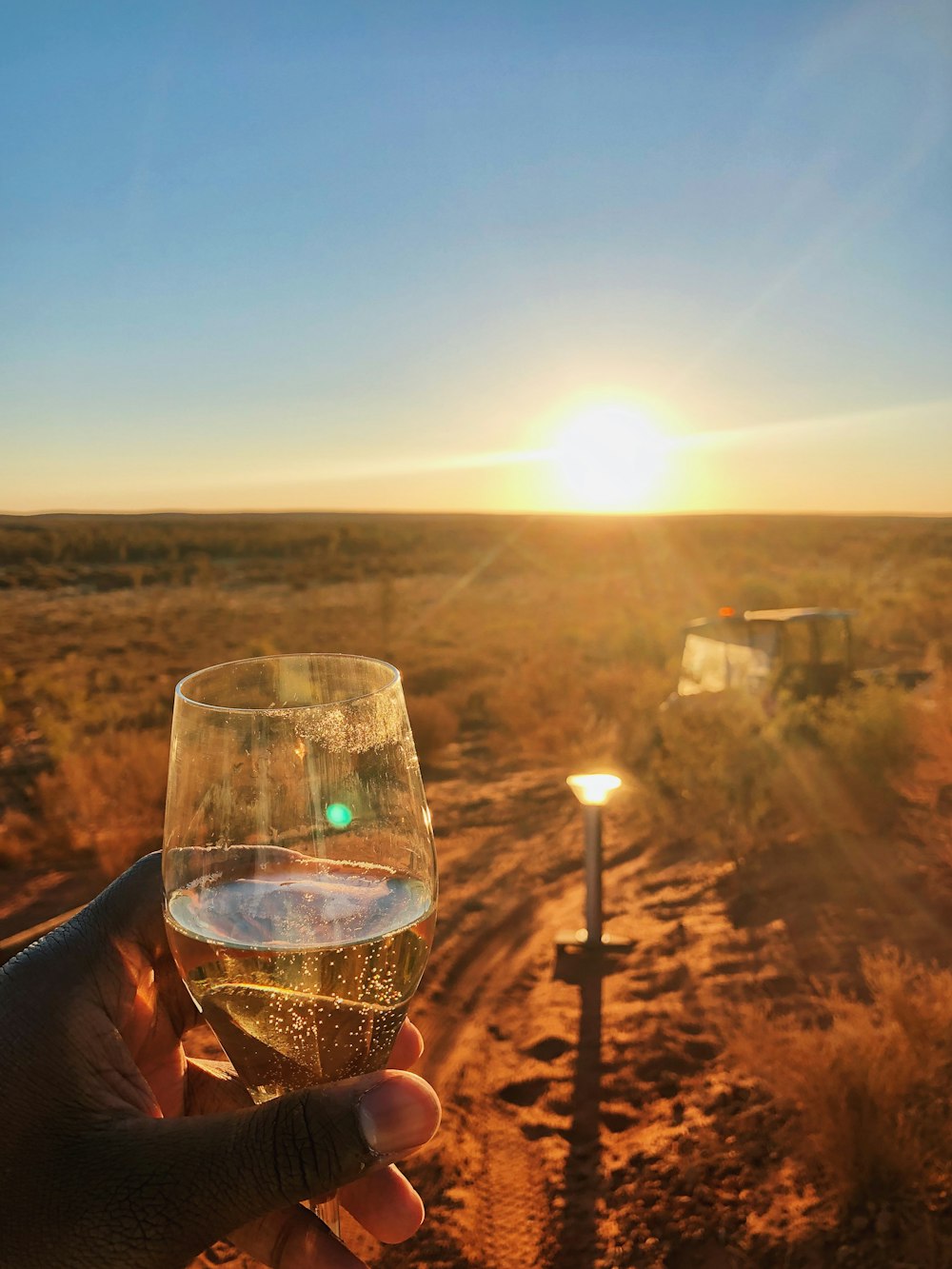 verre de champagne clair à travers le coucher du soleil