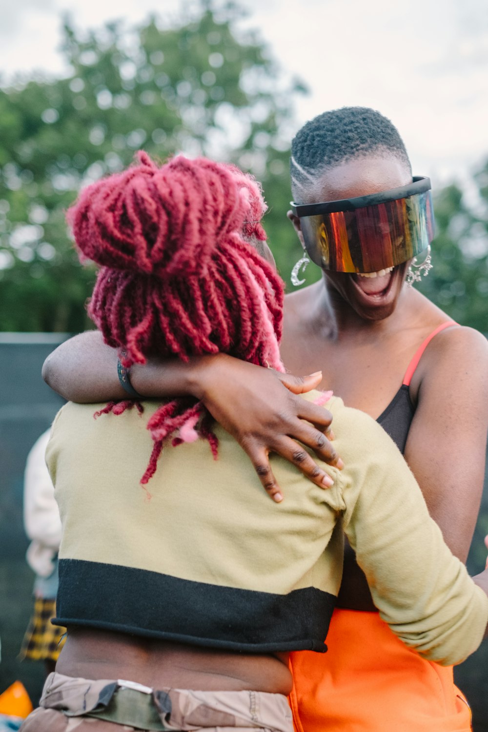 two women hugging during day