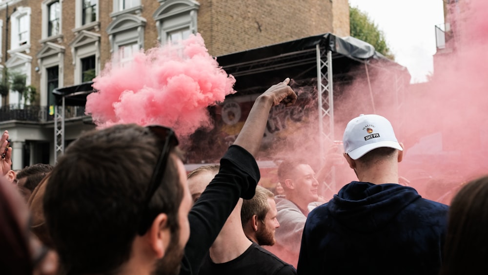 people near pink smoke
