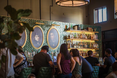 A lively bar scene with friends sharing drinks, bathed in cozy bordeaux and gold tones.