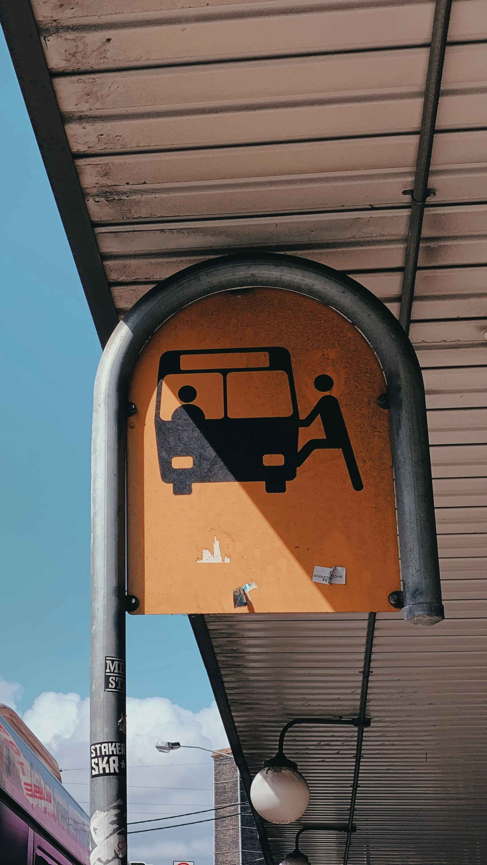 A bus stop sign with a bus in the background photo – Free Vehicle Image ...