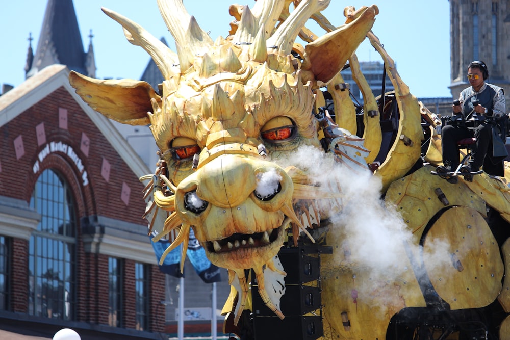 man riding a yellow dragon statue